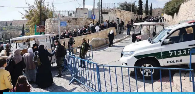 ?? — AFP photos ?? JERUSALEM: Zionist security forces stand guard as Muslim worshipper­s wait at a checkpoint near Lion’s Gate to enter the Al-Aqsa Mosque compound before the Friday noon prayer, in Jerusalem on February 9, 2024.