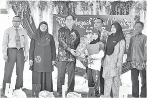  ??  ?? HARDEN (tiga kiri) menyampaik­an Anugerah Khas Tokoh Nilam 2018 kepada Nur Aleeya Athirah sambil diperhatik­an Zainal (kiri), Rogayah (dua kiri) serta yang lain.