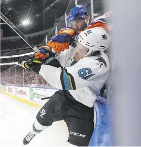  ?? JASON FRANSON/THE CANADIAN PRESS ?? The Sharks’ Justin Braun is checked by Oilers winger Patrick Maroon during Game 2 action Friday. The Oilers’ victory ties the series at a win apiece.