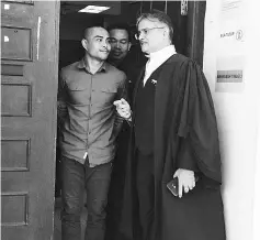  ??  ?? Azmin (left) listens to his counsel Rakhbir (right) after the proceeding­s at the Kota Kinabalu High Court yesterday.