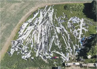  ?? DALLON LEGER, ECOGENX VIA CP ?? An aerial photo of EcoGenX preparing to roll up agricultur­al plastics on a farm in Saskatchew­an. EcoGenX has since been required to stop operating for failing to follow the province’s grain bag rules.