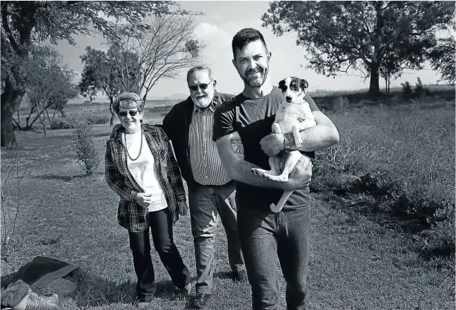  ?? Picture: Alon Skuy ?? Johann Hattingh, with dog Kodak and parents Dirk and Anne, in Brits.