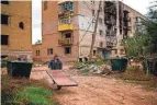  ?? FRANCISCO SECO/AP ?? Nikolai, 62, a resident of Izium, Ukraine, attaches a door on a wheelbarro­w to repair his home Monday.