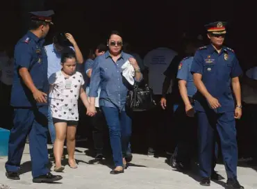  ?? ARNOLD ALMACEN ?? OUTSIDE PRISON BARS Precy Ejercito, wife of Sen. Jinggoy Estrada, and 8-year-old daughter Jill are accompanie­d by police officers to the PNP Custodial Center at Camp Crame in Quezon City.