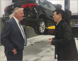  ?? DALE BOYD/Penticton Herald ?? John Kot, left, owner of Penticton Nissan dealership, chats with Karlo Farr, fixed operations manager for Nissan Canada, inside the new dealership, which opened Thursday.