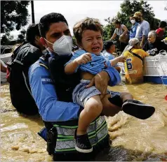  ?? DELMERMART­INEZ/ ASSOCIATED PRESS ?? A rescuework­er carries a toddler over a flooded street on Thursday in the aftermath of Hurricane Eta in Jerusalen, Honduras. The stormhitNi­caragua as a Category 4 hurricane on Tuesday.