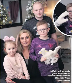  ?? FREDDIE PARKINSON ?? Kai Evitt with his special
gloves and his mother Deborah, father Darren and
little sister Ariana