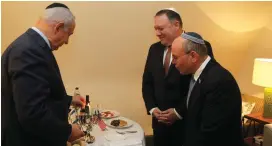  ?? (Gabi Farkash) ?? PRIME MINISTER Benjamin Netanyahu takes a break from his meeting in Brussels yesterday with US Secretary of State Mike Pompeo (center) to light Hanukkah candles, as National Security Council head Meir Ben-Shabbat looks on.