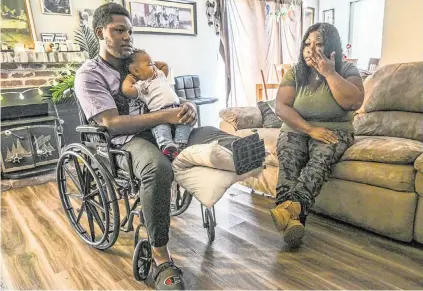  ?? RENÉE C. BYER rbyer@sacbee.com ?? Dirk Couvson, 20, holds daughter Kaili, who turned 1 in March, last month as his mother Lythia Bouie wipes tears while they talked about the emotional and financial hardship he faces after he lost his left leg in a vehicle collision in Sacramento.