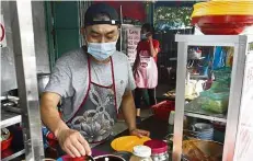  ?? — ZHAFARAN NASIB/ The Star ?? Staying resilient: Ooi selling noodles at Anson Road, Penang.