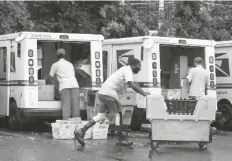  ?? ASSOCIATED PRESS ?? IN THIS JULY 31 FILE PHOTO, letter carriers load mail trucks for deliveries at a U.S. Postal Service facility in McLean, Va.