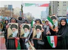  ?? FOTO: NOROOZI/AP ?? Iranerinne­n halten das Konterfei ihres religiösen Führers Ayatollah Chamenei vor sich. Im ganzen Land feierten Tausende den Revolution­stag.