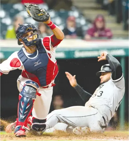  ??  ?? Indians catcher Yan Gomes can’t prevent Melky Cabrera from scoring in the eighth inning Thursday. | JASON MILLER/ GETTY IMAGES