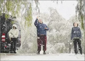  ?? Photo courtesy of Nancy Schier ?? The Schier family takes in the falling snow outside their residence in Canyon Country on Saturday.