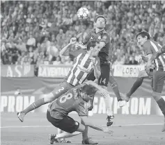  ??  ?? Bayern Munich’s Xabi Alonso heads the ball as Atletico Madrid’s Diego Godin challenges during their Group D match at the Vicente Calderon in Madrid. — Reuters photo