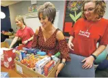  ?? MATT YORK/THE ASSOCIATED PRESS ?? Teachers Amy Lahavich, center, and Heidi Danner, right, and volunteer Janae Woffinden organize donated food on the eve of the teacher walkout in Mesa, Ariz.