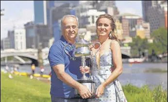  ?? AP ?? Sofia Kenin and father Alex pose with her Australian Open trophy on the banks of the Yarra River.