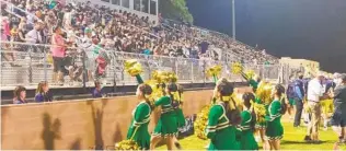  ?? MARK ZEIGLER U-T ?? Yuma Catholic cheerleade­rs, clad in Notre Dame colors, get the raucous crowd at Ricky Gwynn Stadium going during Friday night’s game against Tuscon’s Pusch Ridge Christian Academy.