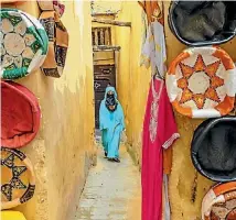  ?? ISTOCK/PAVLIHA ?? A woman in a blue djellaba walks through the medina in Fez.