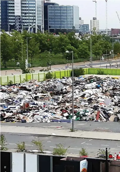  ??  ?? Eyesore: The waste site is in the shadow of the Olympic swimming pool with its curved roof