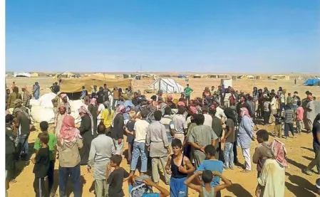  ??  ?? Victims of war: Displaced people waiting for aid at the Rukban camp near the Jordan-Syria border. — AP