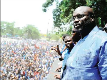  ?? ZOOM DOSSO/AFP ?? Former internatio­nal football star George Weah looks at his supporters at his party’s headquarte­rs in Monrovia on April 28, 2016.