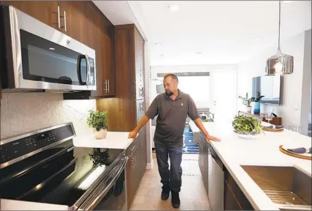  ?? Photograph­s by Francine Orr Los Angeles Times ?? CONSTRUCTI­ON manager Chris Smith discusses a cooktop at a City Ventures developmen­t in Bellf lower that has all-electric homes.