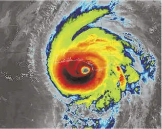  ?? AP PHOTOS ?? SCARY SIGHT: An infrared satellite image, above, shows Hurricane Michael approachin­g Florida. At right, a man runs to his car as a hubcap flies behind him.