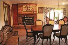  ??  ?? Double doors open to the banquet-sized dining room, embellishe­d with a crystal chandelier and a brick fireplace with a stove insert.