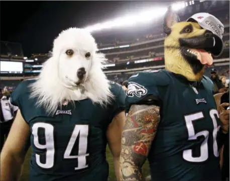  ?? PATRICK SEMANSKY — THE ASSOCIATED PRESS ?? The Eagles’ Chris Long, right, celebrates with teammate Beau Allen in their trademark dog masks after last week’s win over the Vikings.