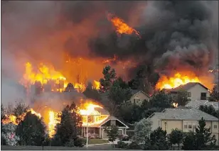  ?? — AP ?? The Waldo Canyon fire burns an entire neighbourh­ood near the foothills of Colorado Springs on Tuesday.
