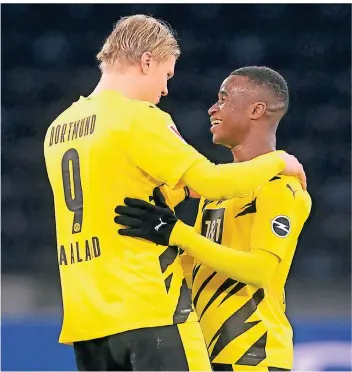  ??  ?? Dortmunds Fans träumen von diesen beiden als Sturmduo der nahen Zukunft: Erling Haaland (l.) und Youssoufa Moukoko umarmen sich nach Spielende in Berlin.