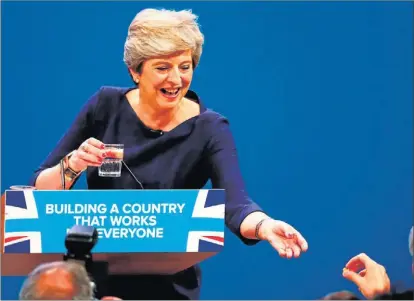  ?? P. NOBLE / REUTERS ?? El secretario del Tesoro Philip Hammond ofrece un caramelo a la primera ministra Theresa May.