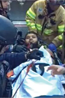  ??  ?? Wounded: Akayed Ullah lies on the floor after his suicide vest exploded near New York’s Times Square yesterday. Right, he is taken to hospital by emergency crews