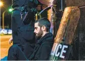  ?? BRANDON BELL GETTY IMAGES ?? A demonstrat­or is detained by law enforcemen­t officers late Saturday night in Louisville, Ky.