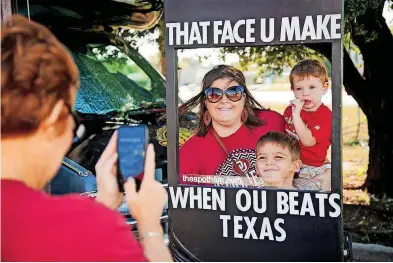  ?? [PHOTO BY CHRIS LANDSBERGE­R, THE OKLAHOMAN] ?? Lyndsey Hause poses for a photo with her sons Carson, right, and Cale at Bevo Bash in Marietta. The party is an annual event for fans en route to Dallas.