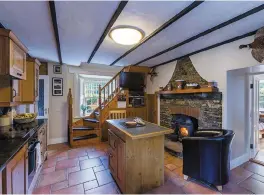  ??  ?? The kitchen has a beamed ceiling and terracotta-tiled floor. Left, the gate lodge has been extended