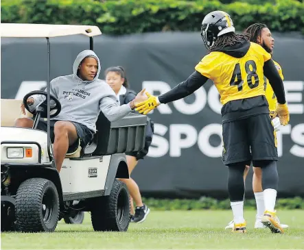  ?? KEITH SRAKOCIC / THE ASSOCIATED PRESS ?? Ryan Shazier, left, high-fives Steelers teammate Bud Dupree at practice Wednesday in Pittsburgh. Shazier is determined to play again, even though he still needs a cane to walk after spinal surgery.