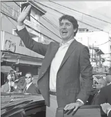  ?? CP PHOTO ?? Prime Minister Justin Trudeau waves to locals gathered outside a women’s health centre in Manila, Philippine­s, Sunday.