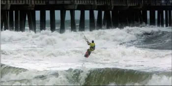  ?? L. Todd Spencer/The Virginian-Pilot via AP ?? Kite Boarder Dimitri Maramenide­s heads out next to Jennette’s Pier in Nags Head, N.C., as Hurricane Florence makes landfall further south on Friday.