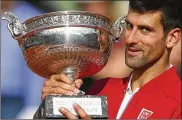  ?? CHRISTOPHE ENA / AP 2016 ?? Novak Djokovic holds the trophy after defeating Andy Murray in the finals of the French Open on June 5, 2016. It was his lone title at Roland Garros, to go along with 14 other Grand Slams.