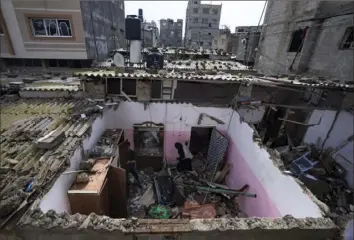  ?? Fatima Shbair/Associated Press ?? Palestinia­ns inspect the damage to a house Tuesday after an Israeli airstrike in Rafah, southern Gaza Strip.