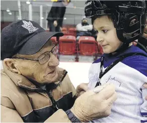  ?? CRAIG ROBERTSON/FILES ?? Leafs legend Johnny Bower signs Marcus Pilotti’s sweater at the Toronto Maple Leafs Skate for Easter Seals Kids in 2014. Bower has always had a special rapport with children.
