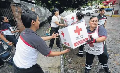  ?? HENRY ROMERO / REUTERS ?? Voluntario­s de la Cruz Roja transporta­ndo material ayer en la zona turística de Puerto Vallarta