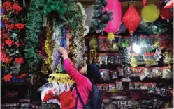  ?? AFP ?? AIZAWL: An Indian Mizo store keeper hangs Santa hats outside her shop in Aizawl, capital of northeaste­rn Mizoram state, yesterday. Apart from household activities, Mizo women control most of the business in Mizoram state. —