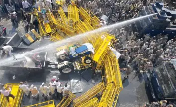  ?? — G. N. JHA ?? Policemen use water cannons as a farmer rams his tractor into the barricades at Ghazipur near the Delhi- UP border during the “Kisan Kranti Padyatra” in New Delhi on Tuesday.