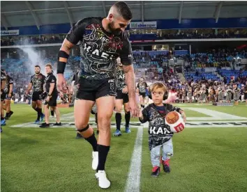  ??  ?? Der gehänselte Quaden Bayles betritt mit Captain Joel Thompson das Cbus Super Stadium.
AP