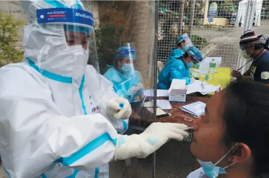  ?? Photo by Dave Leprozo Jr. ?? TESTING TO THE BARRIOS. Government health workers conduct Covid-19 mass testing to the different barangays in the town of Tuba, Benguet in line with the province’ aggressive mass testing program.