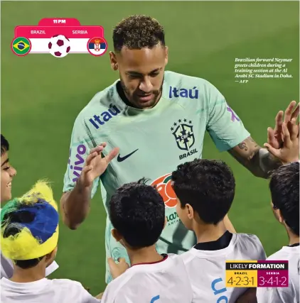  ?? ?? Brazilian forward Neymar greets children during a training session at the Al Arabi SC Stadium in Doha. — afp