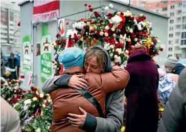  ?? AP ?? Two women embrace as people gather in Minsk to honour Belarusian opposition supporter Raman Bandarenka, who died in hospital after he was reportedly beaten by security forces.